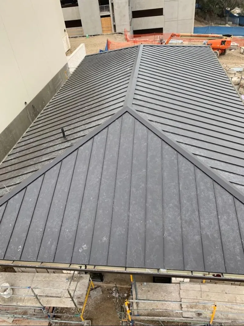 Commercial metal roof construction with crane equipment in Camillus